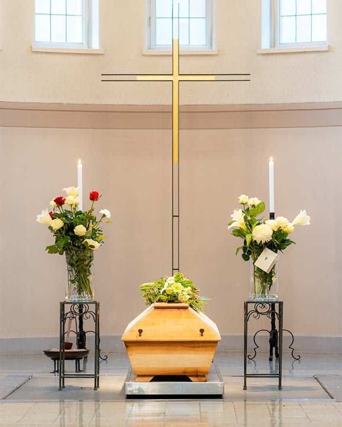 Hautajaiset Kalevankankaan isossa kappelissa. Kuvassa kauniisti kukitettu arkku. Hautajaiset valokuvasi Joni Pystö